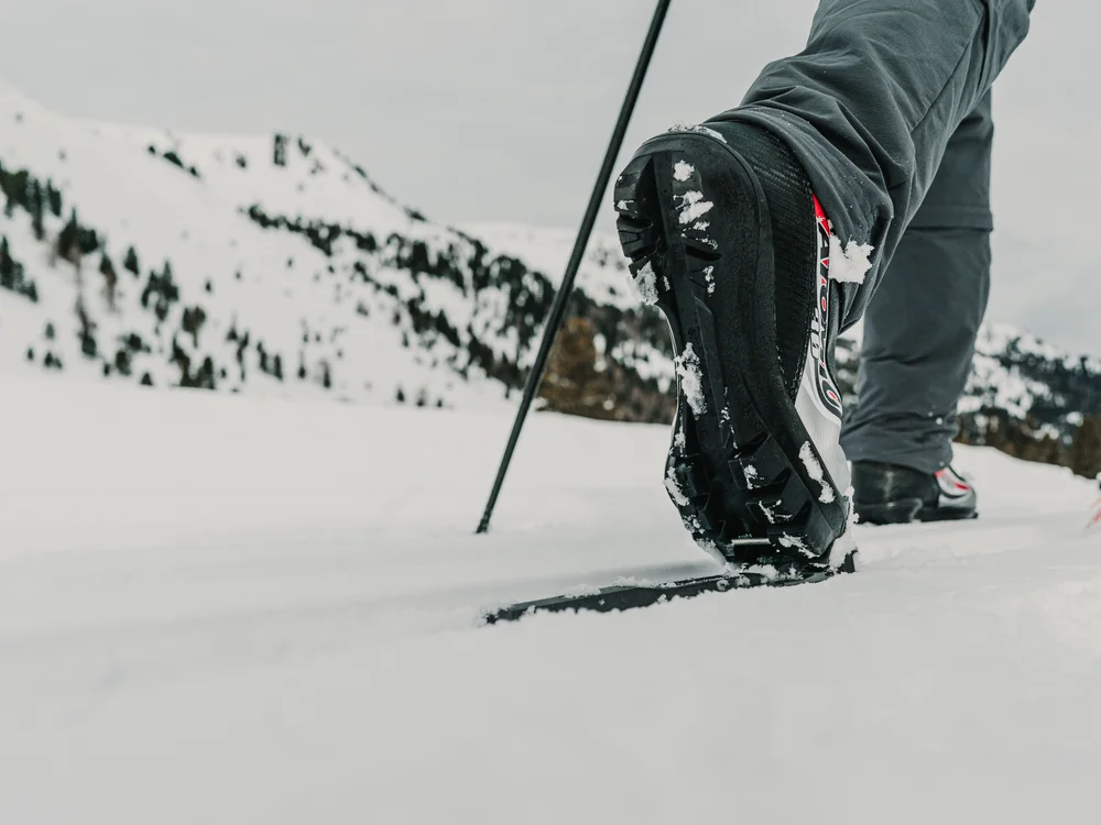 GRETI in Bad Hofgastein: dein alpines Boutique Hotel Nahaufnahme eines Skischuhs auf einem Ski im verschneiten Gebirge