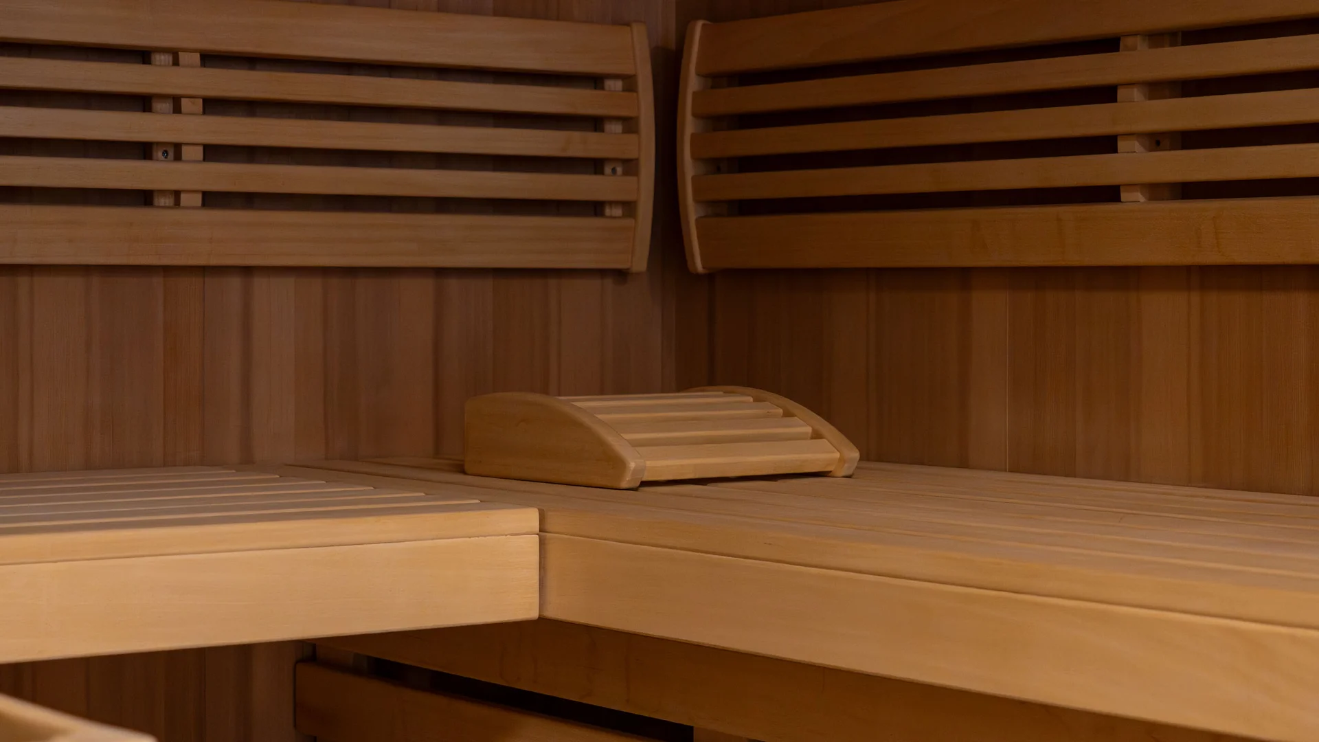Holzsauna mit Sitzbänken und hölzernen Rückenlehnen